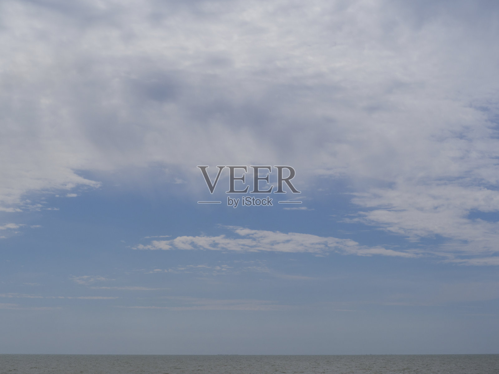 蔚蓝的天空,海面上飘着雨云。白色的灰色云,从它下雨。照片摄影图片