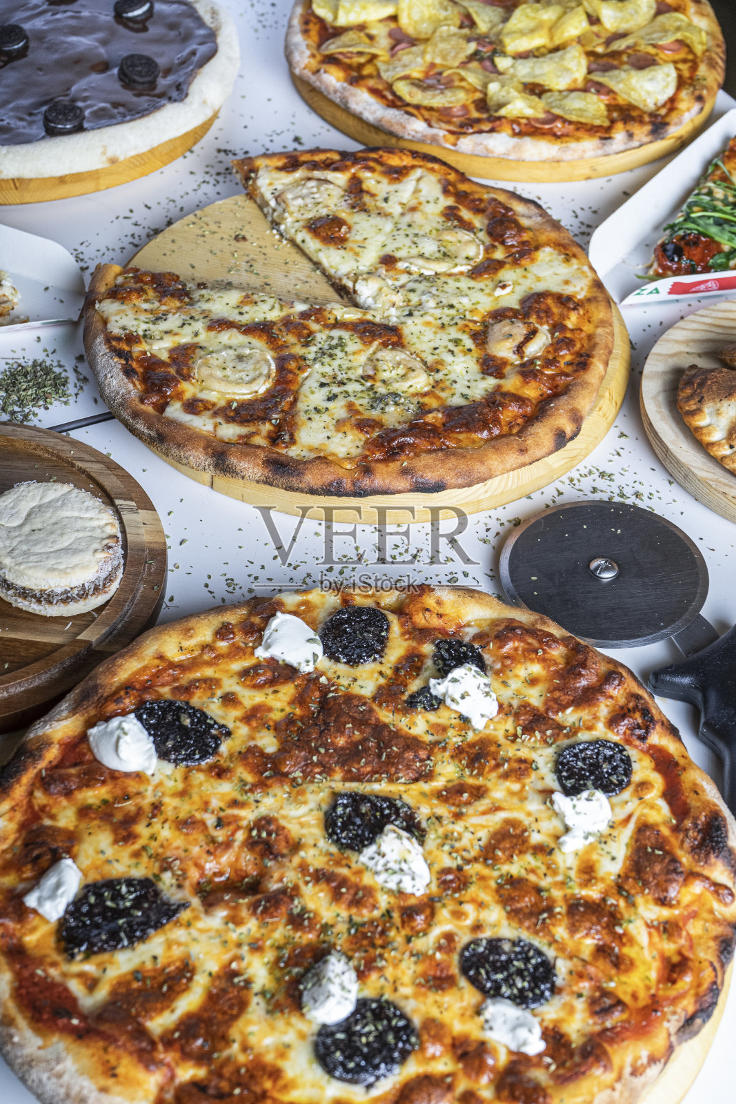 餐厅桌上各种各样的披萨可以吃。垂直图照片摄影图片