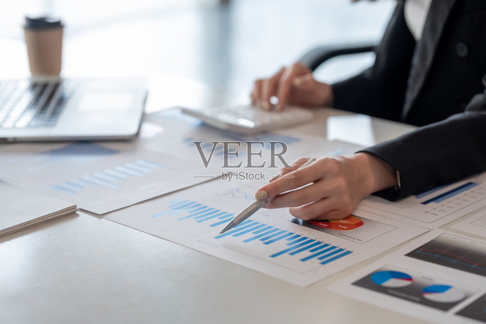 关闭了。女商人在办公室工作分析指向图。照片摄影图片