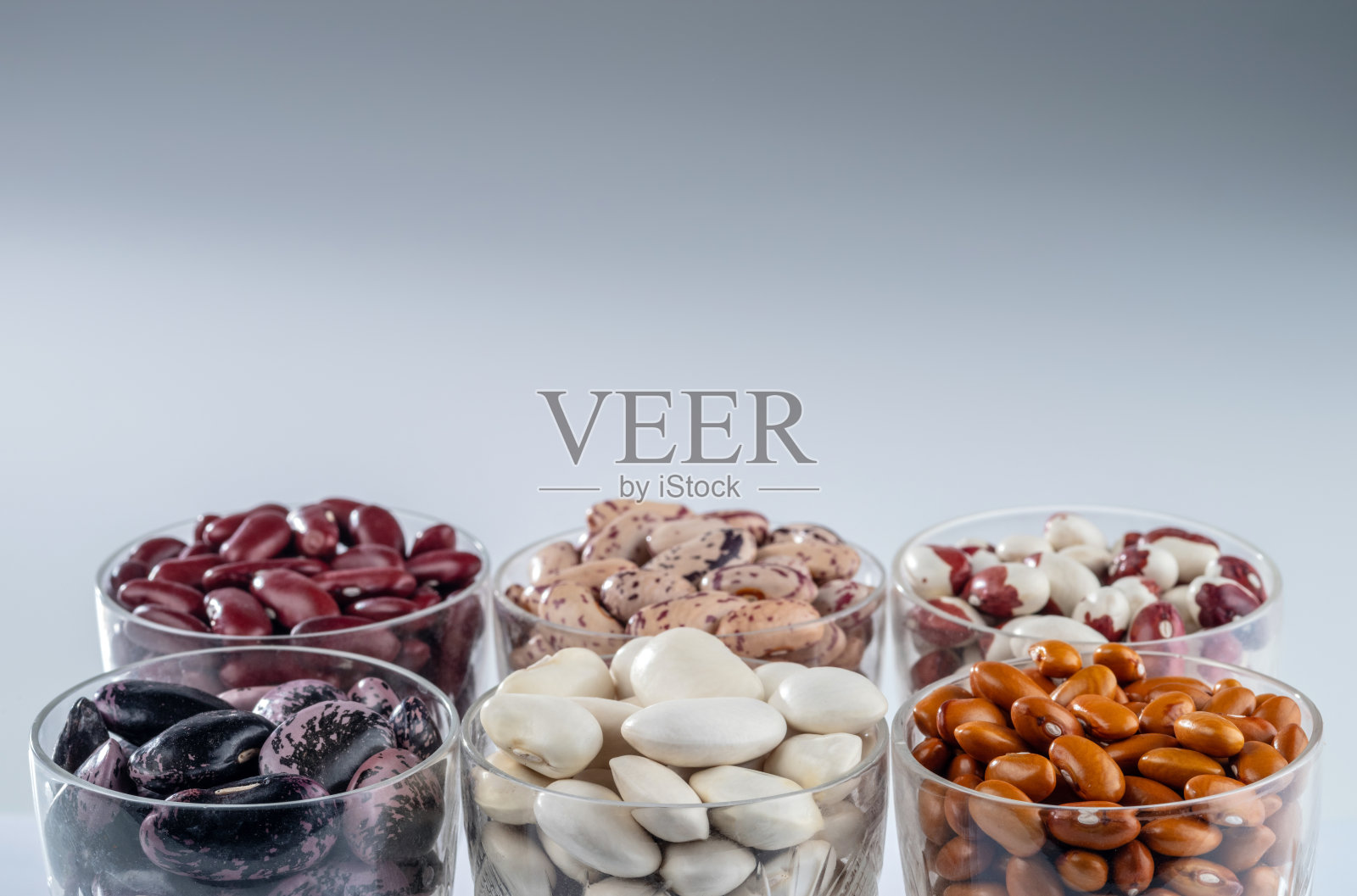 六种不同品种的豆子在一个灰色的圆形玻璃器皿上照片摄影图片