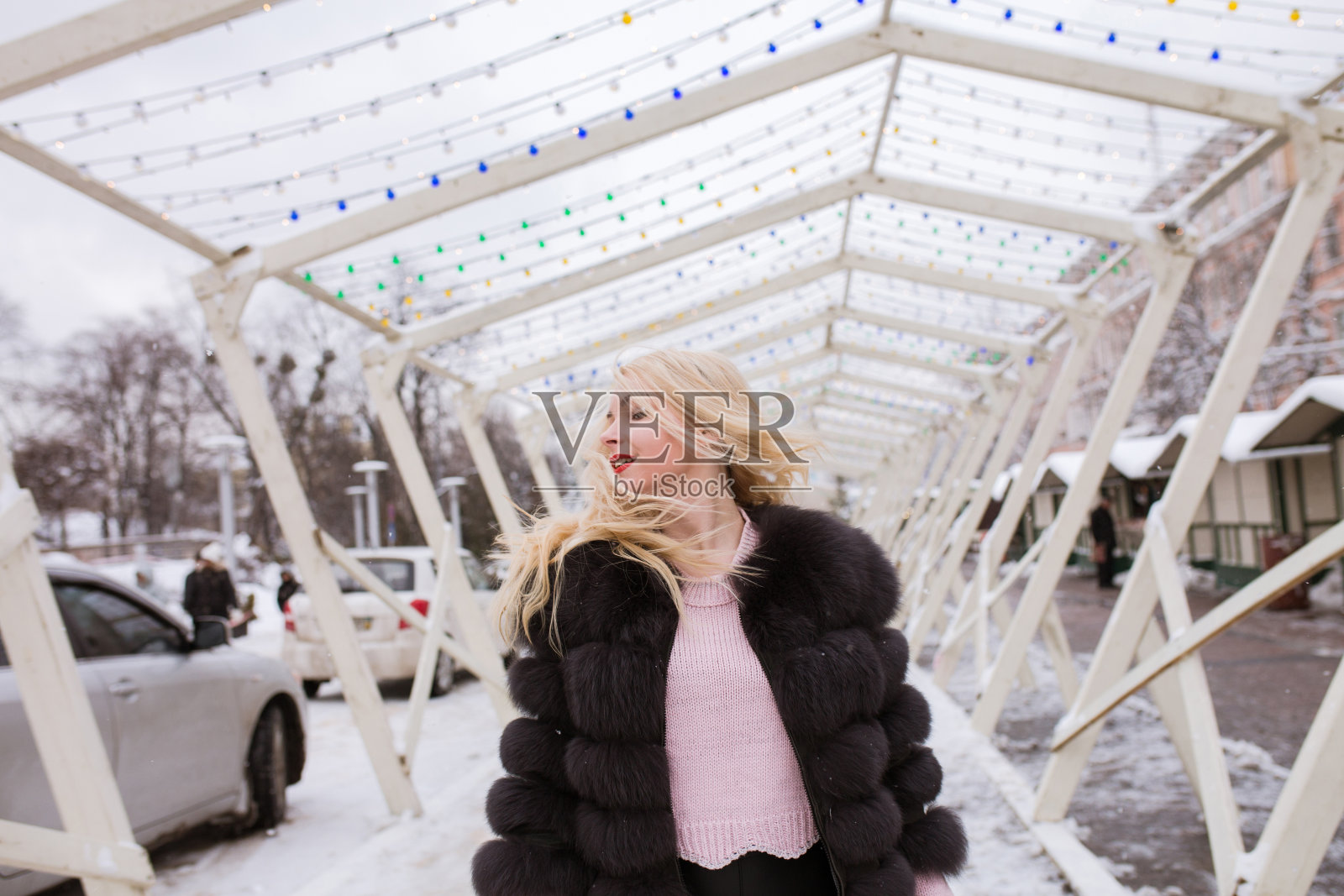 漂亮的金发女人在雪地里摆姿势照片摄影图片