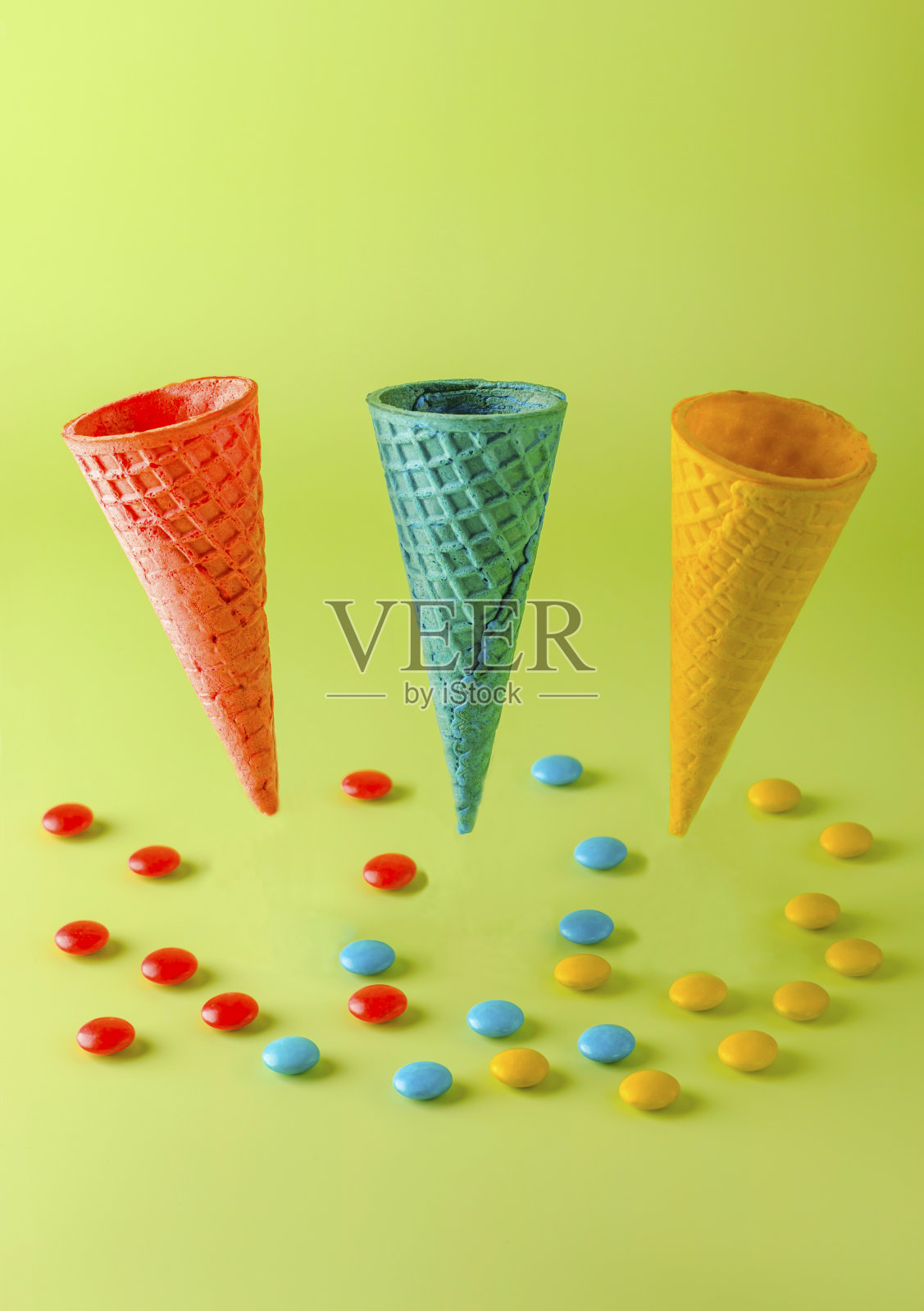 颜色华夫蛋筒的冰淇淋和糖果在一个较轻的背景。夏天创意概念。悬浮。垂直位置照片摄影图片