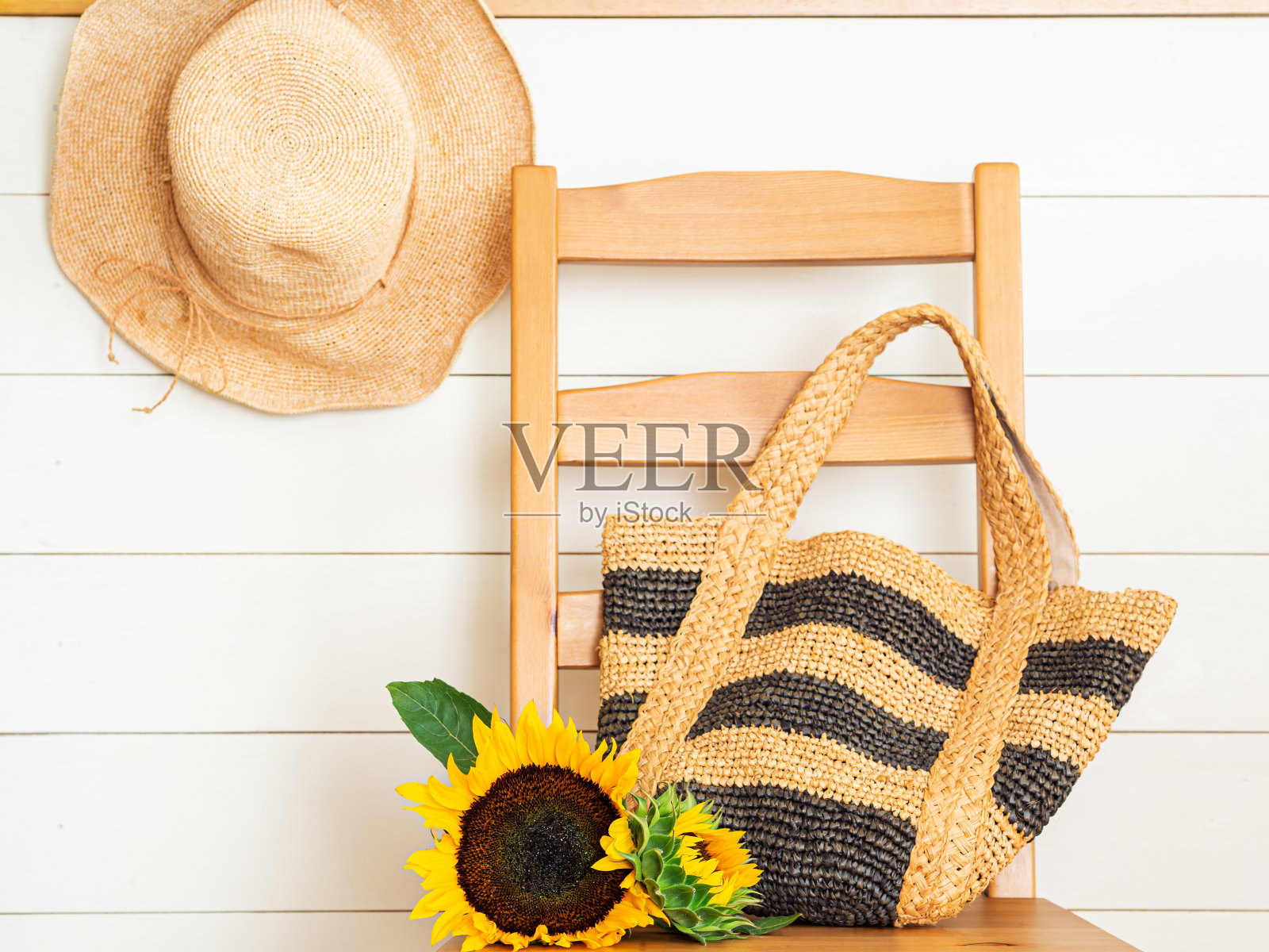 夏天的帽子,袋子和向日葵在椅子上照片摄影图片