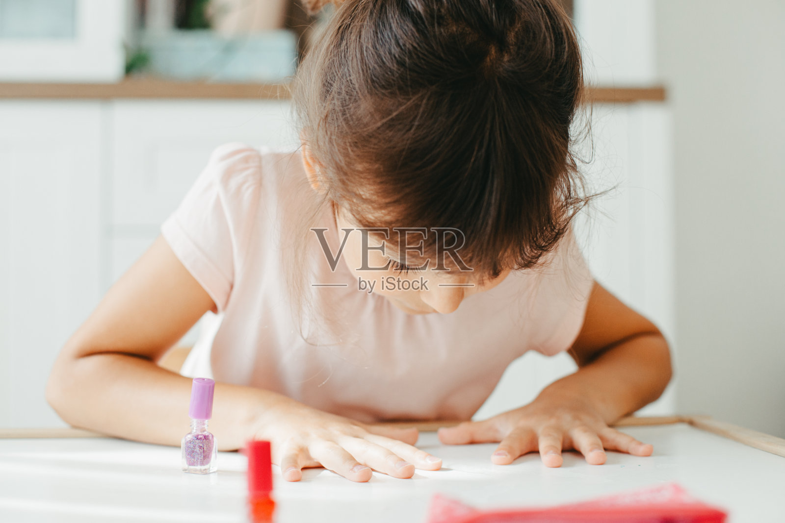 有兴趣的女孩在指甲上涂指甲油照片摄影图片