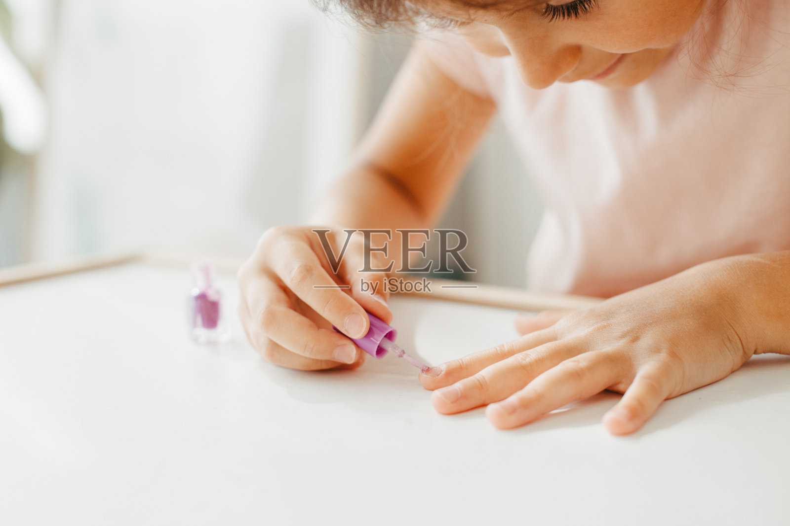 有兴趣的女孩在指甲上涂指甲油照片摄影图片