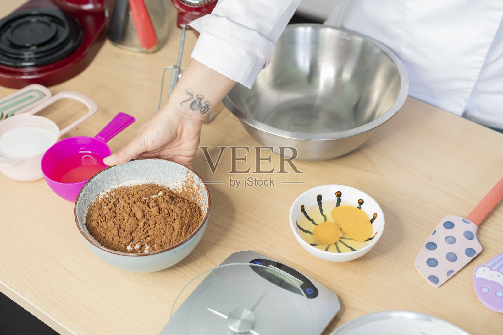 女厨师在直播节目中向粉丝们讲述如何用她的浅色戒指和制服准备蛋糕照片摄影图片