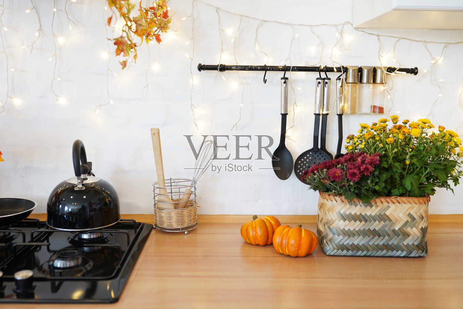 厨房桌子上的五彩秋色静物。南瓜,花束和落叶照片摄影图片