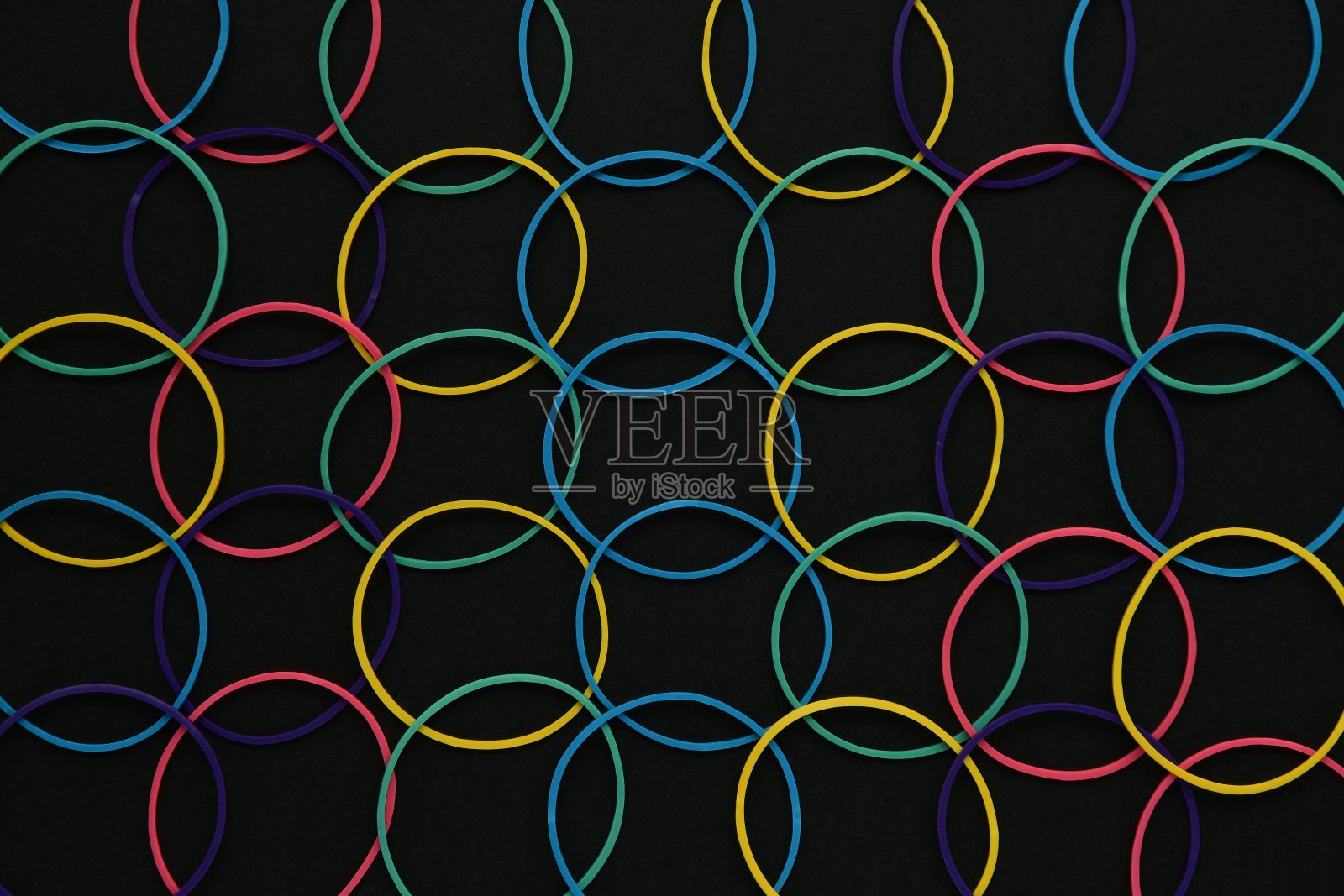 黑色背景上的彩色橡皮筋。照片摄影图片