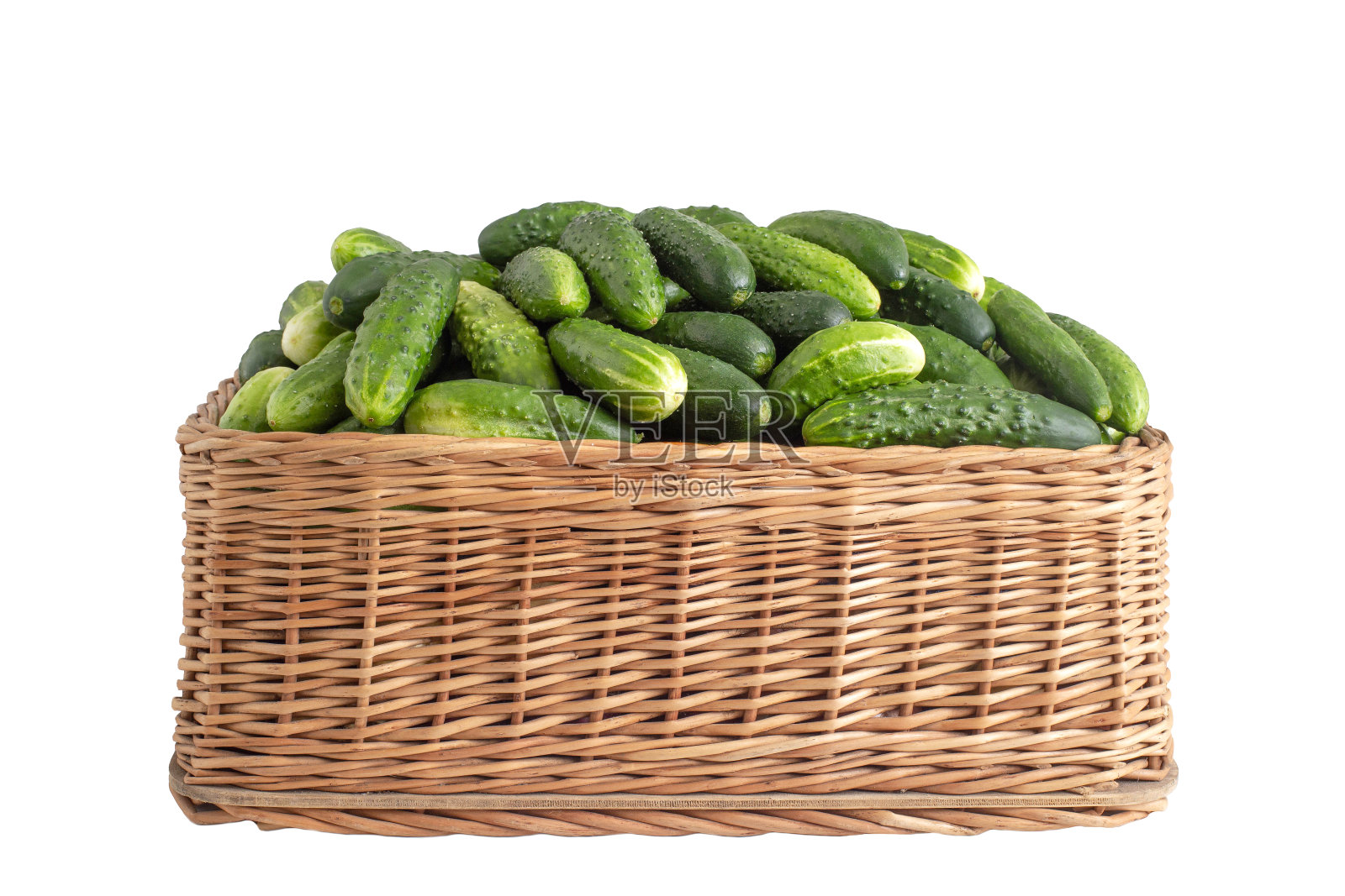 柳条篮子里的绿黄瓜,白色背景,孤立,特写。农业、烹饪照片摄影图片