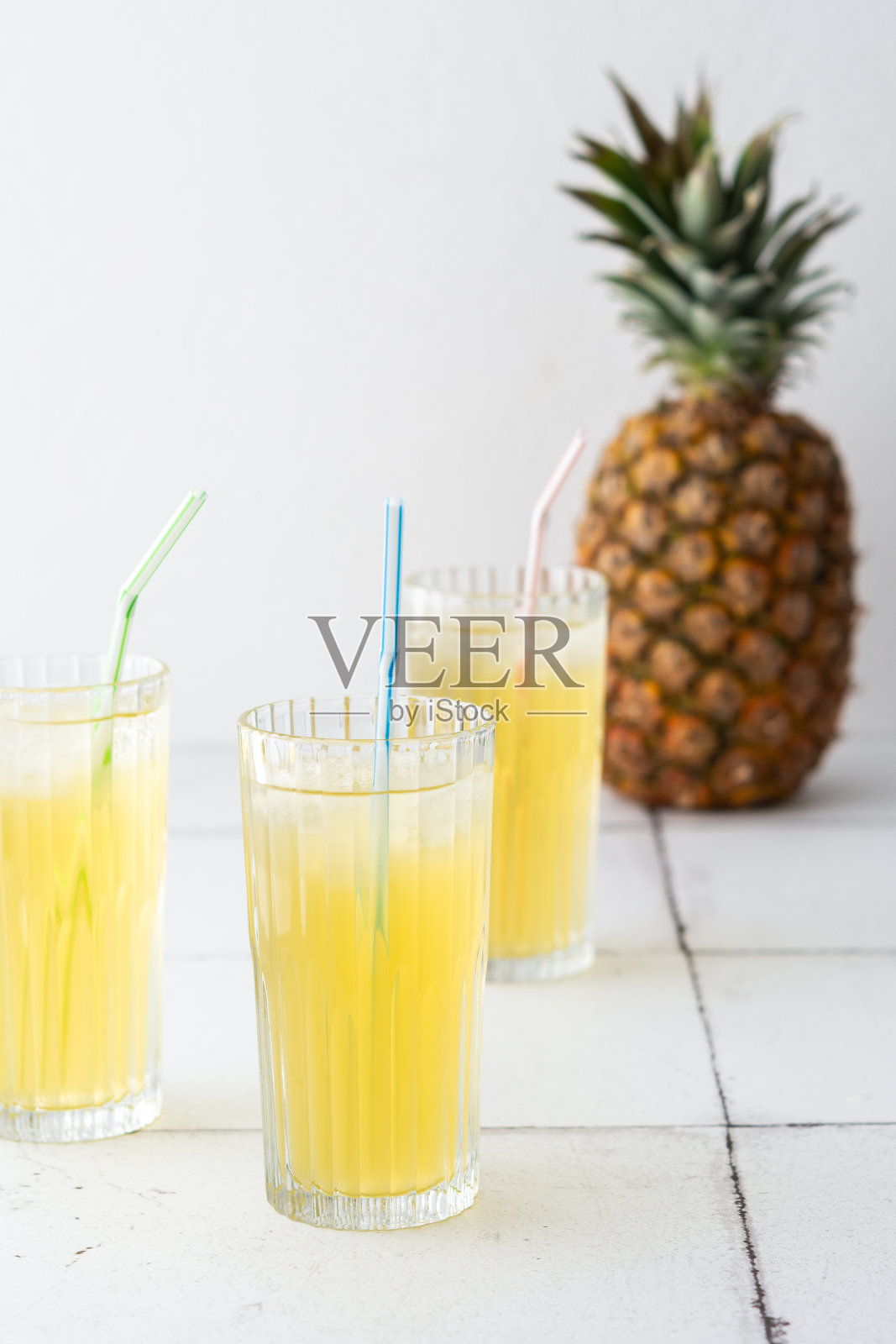 菠萝汁装在杯子里,用吸管照片摄影图片