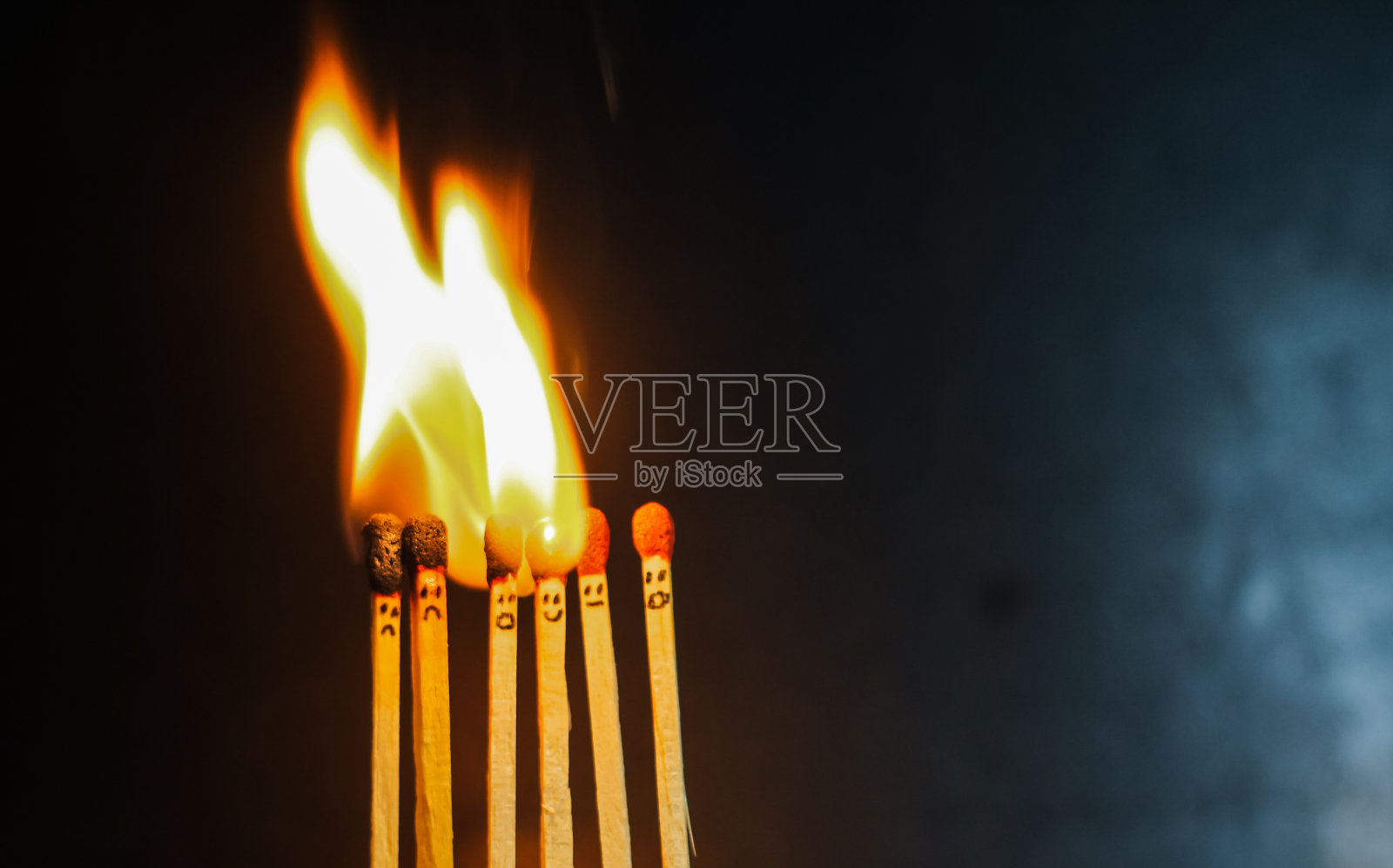 一组燃烧着的红色火柴与背景隔绝。排燃烧火柴的连锁反应。火柴艺术摄影。照片摄影图片