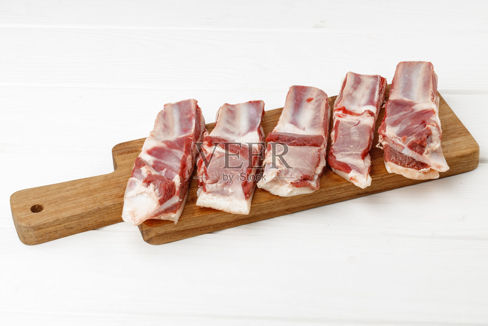 生肉排骨放在木板上,白底照片摄影图片