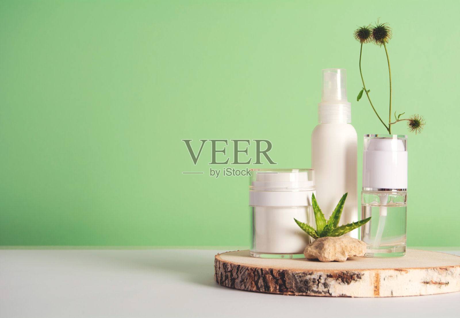 化妆瓶与凝胶或其他化妆品在木制讲台,石头,芦荟照片摄影图片