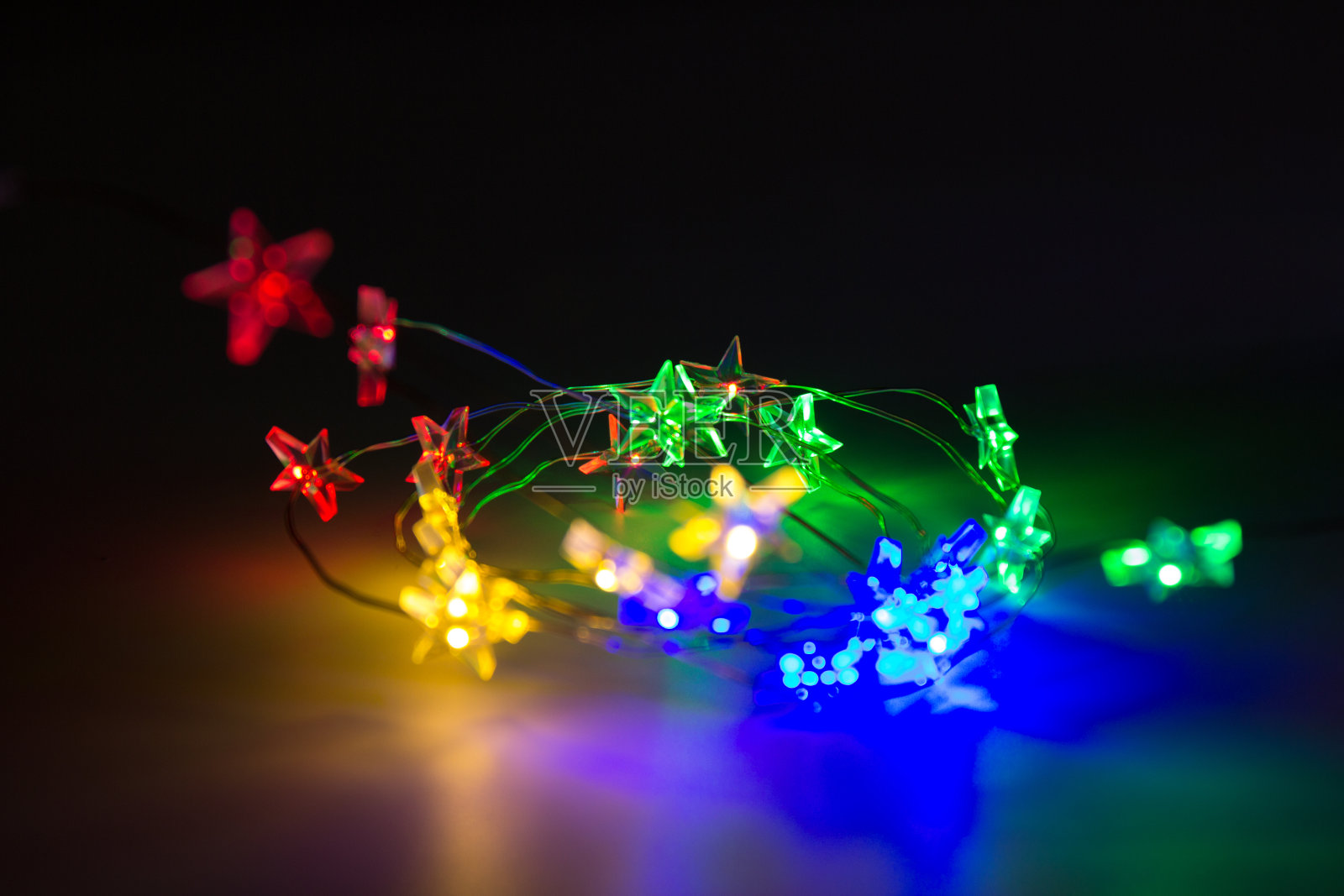 圣诞彩灯在闪闪发光的背景上形成花环照片摄影图片