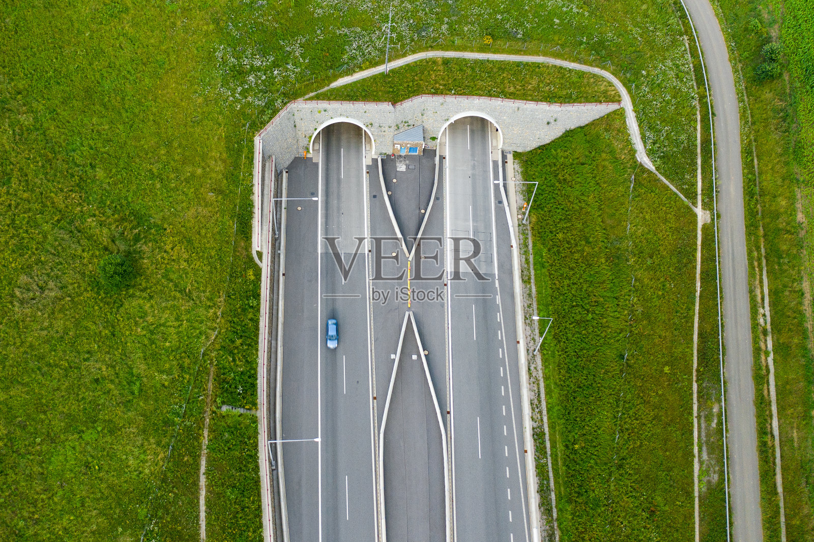 俯视图隧道入口的高速公路上覆盖着绿色的草地照片摄影图片