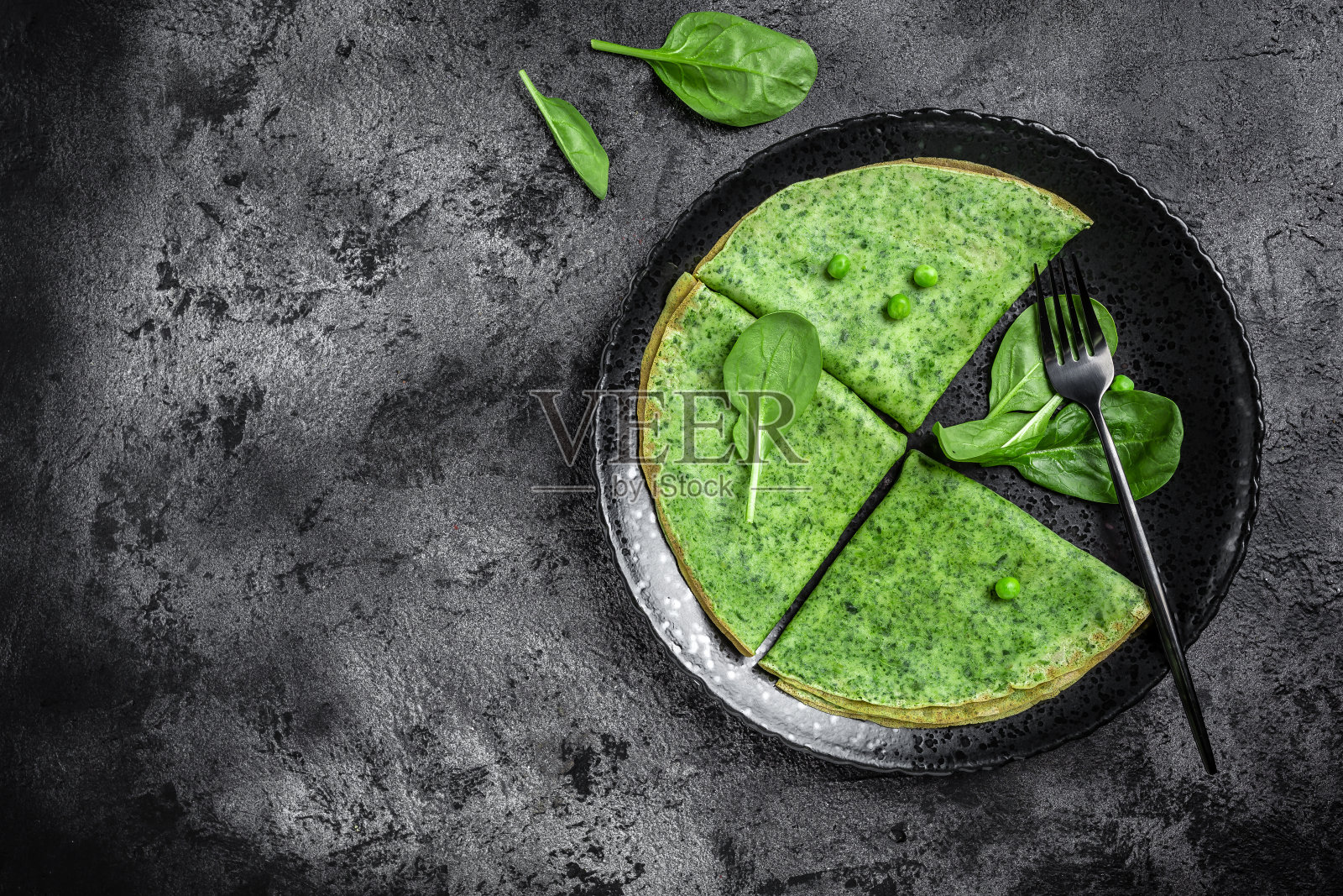 绿色素食薄饼与菠菜在深色的背景。健康早餐,素食,横幅,菜单食谱的文字,俯视图照片摄影图片