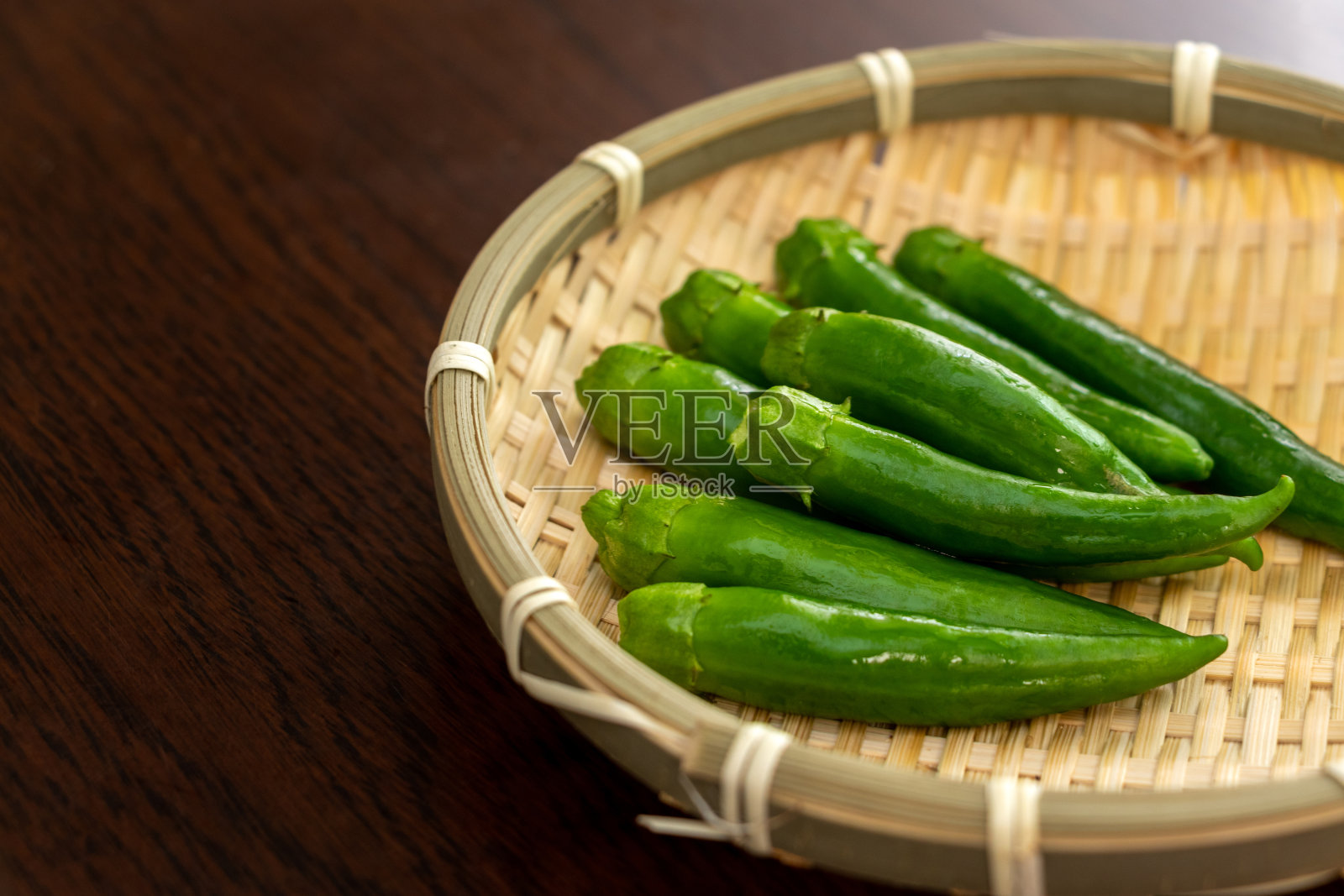 用竹滤锅盛上新鲜的青椒照片摄影图片