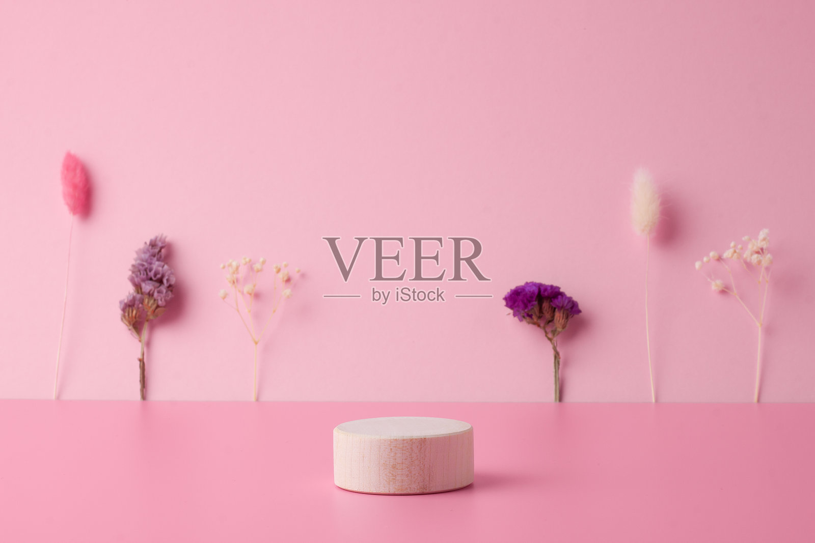 化妆背景与木制讲台和粉红色的花朵。用于化妆品展示的空橱窗。照片摄影图片