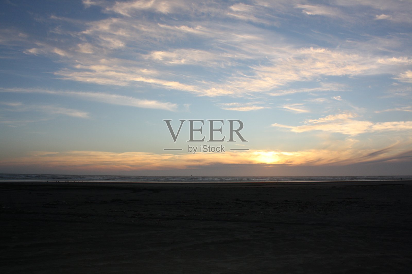 当太阳慢慢落下时,海滩照片摄影图片