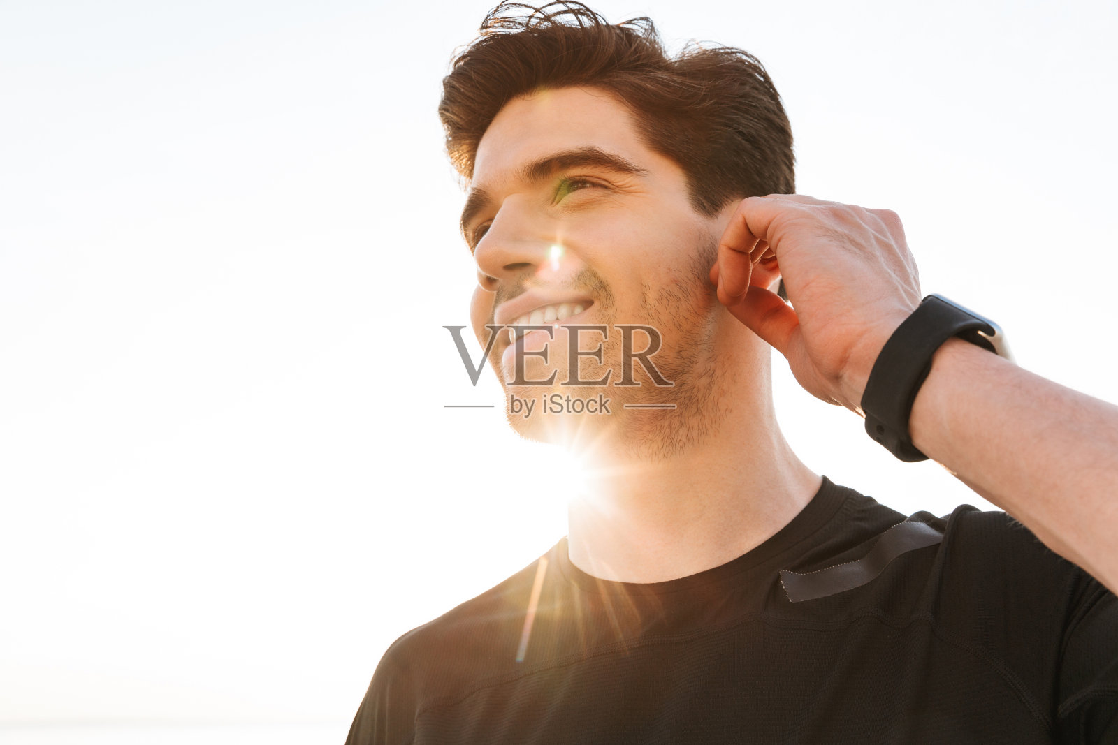 运动员在户外的海滩上听音乐。照片摄影图片