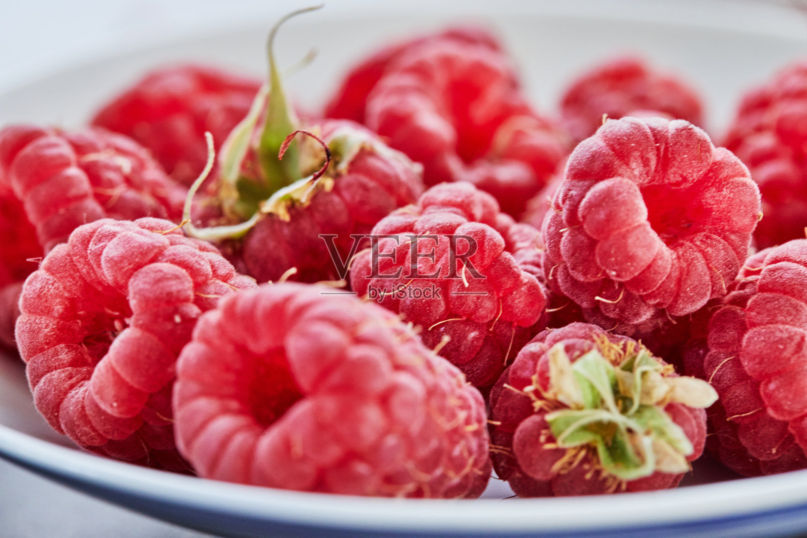 白色盘子上新鲜覆盆子特写拍摄,选择性聚焦照片摄影图片