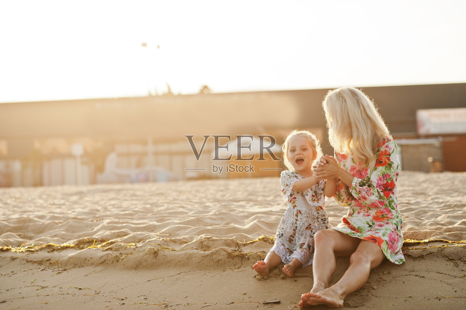妈妈和漂亮的女儿在海滩上玩得很开心照片摄影图片