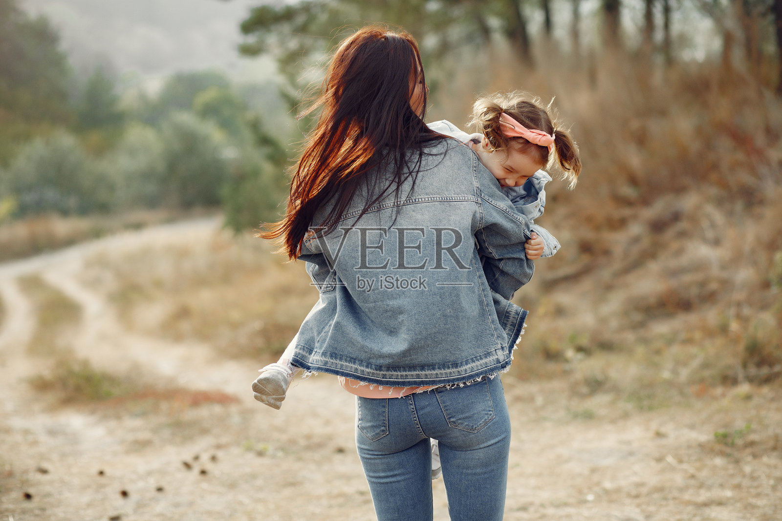 母亲和小女儿在秋天的田野里玩耍照片摄影图片