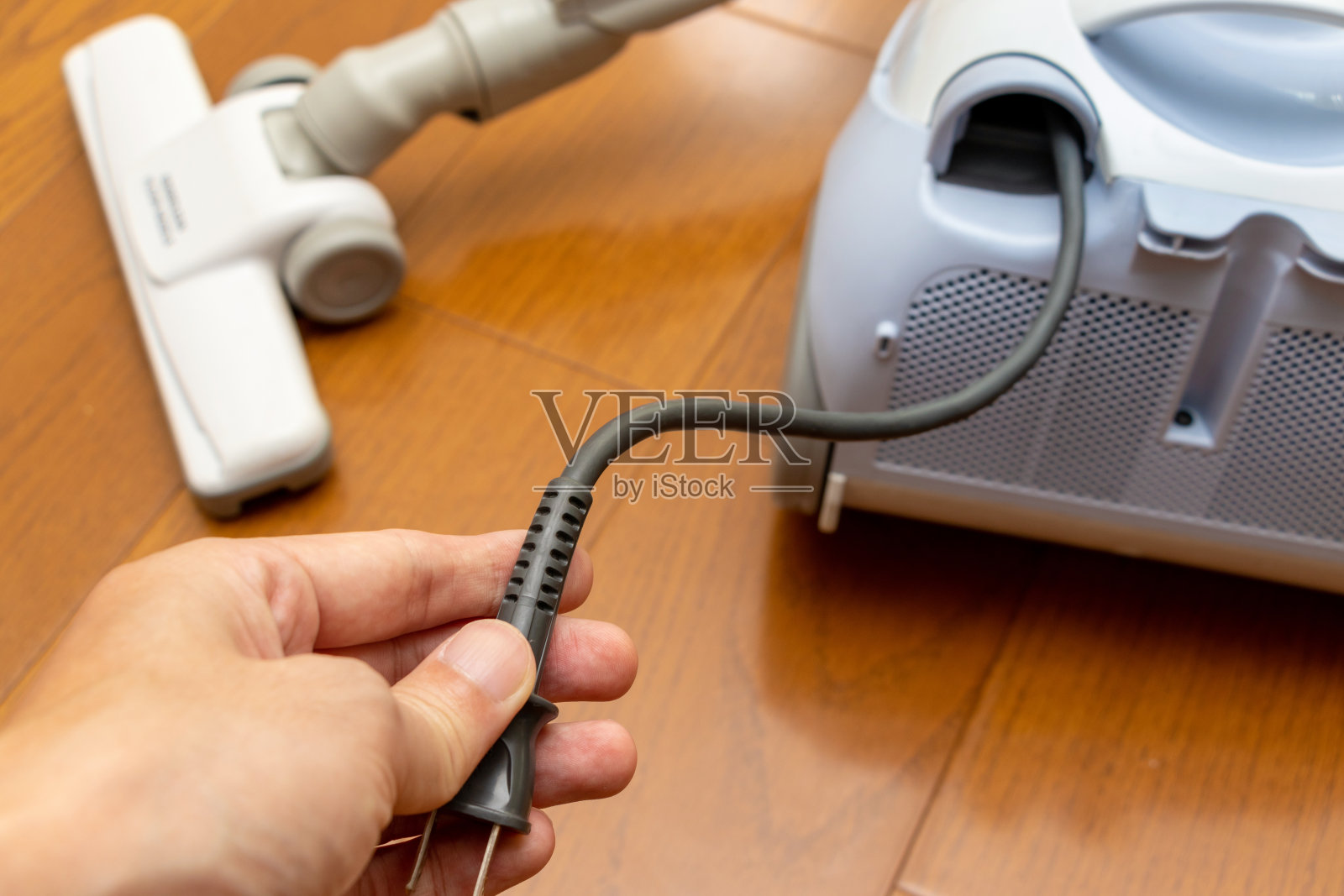 将吸尘器的电源线从主机上拔出照片摄影图片