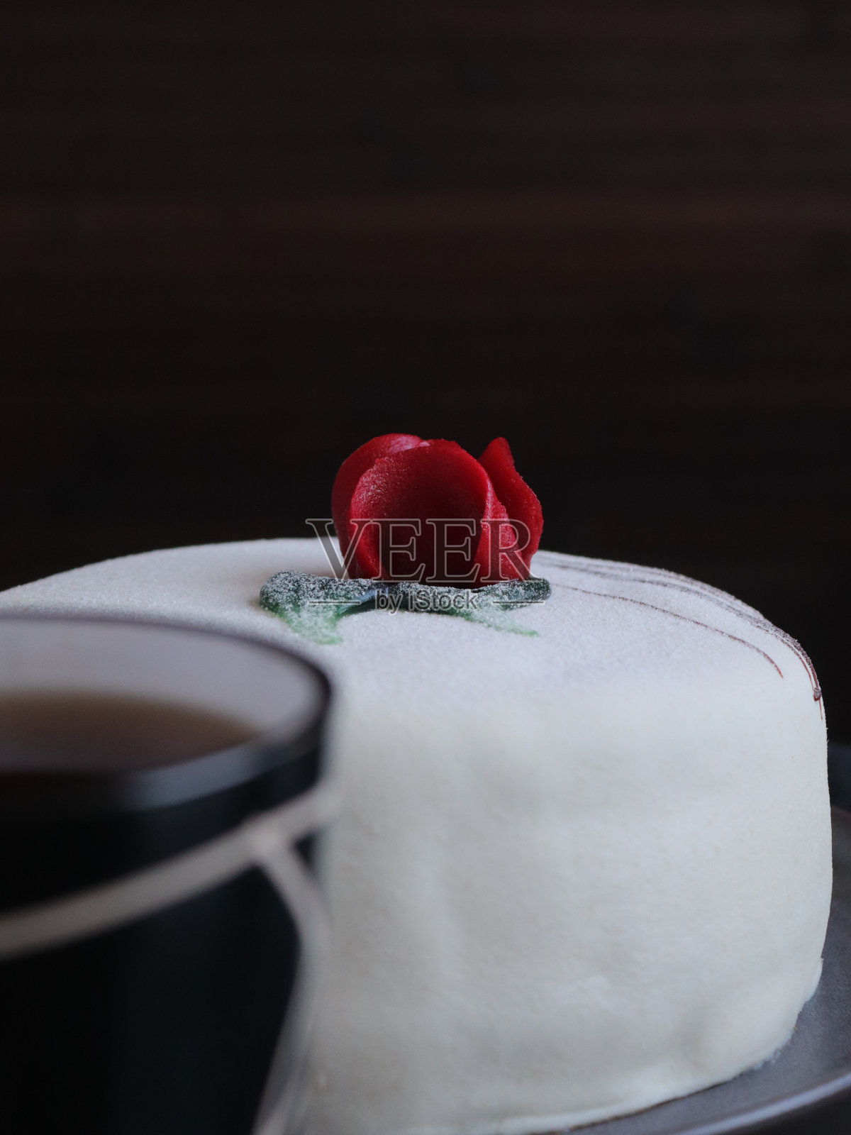 黑色的桌子上放着白色的蛋糕和一杯茶照片摄影图片