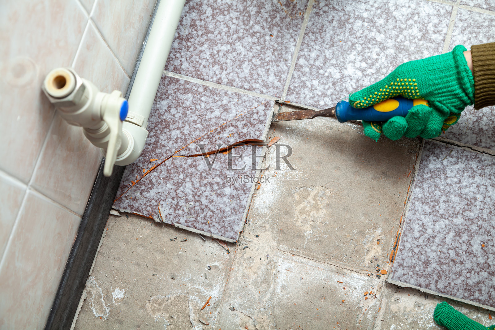 手拿瓷砖用凿子照片摄影图片