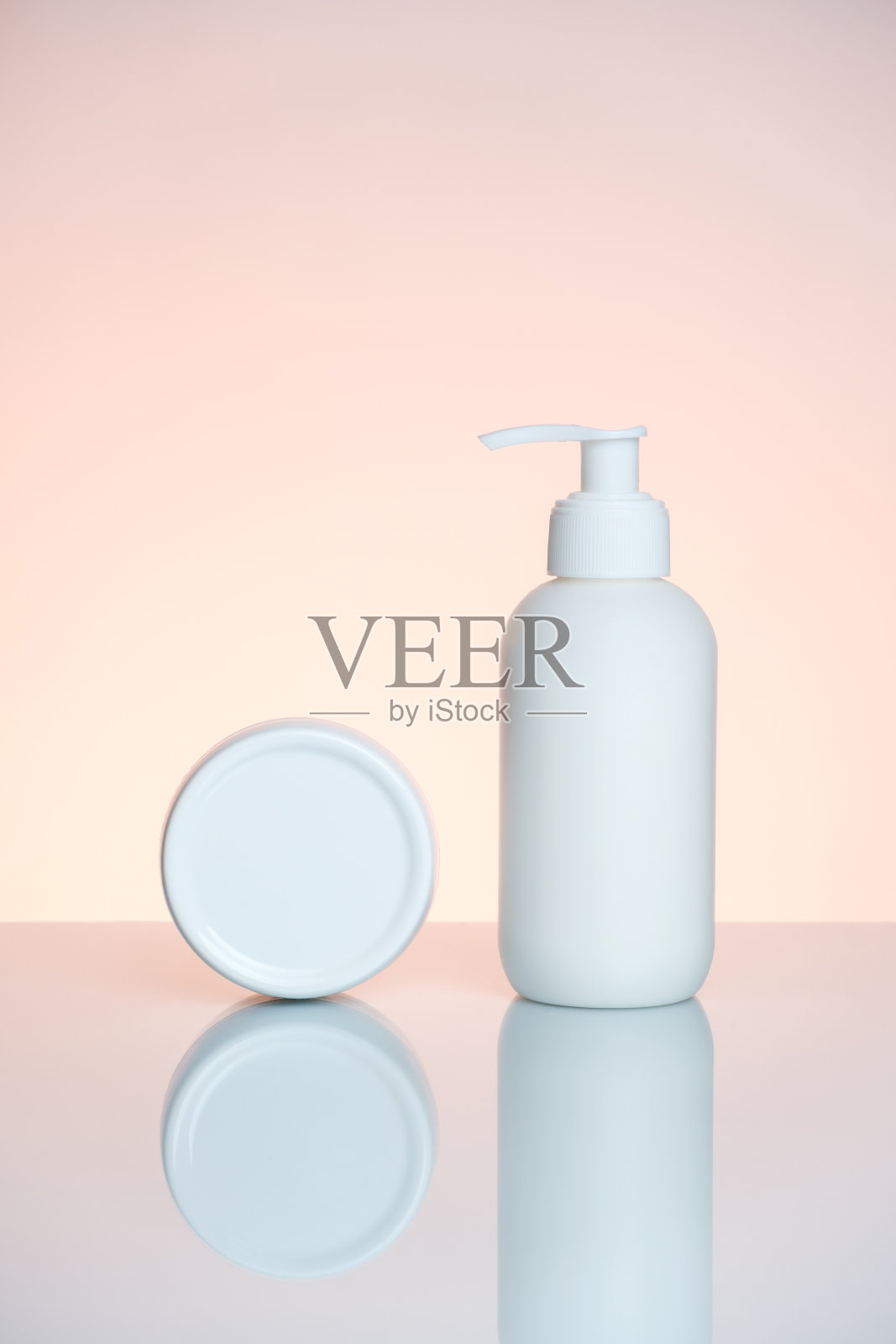 护手霜在一个瓶子和罐子在浅粉色的背景反射。照片摄影图片