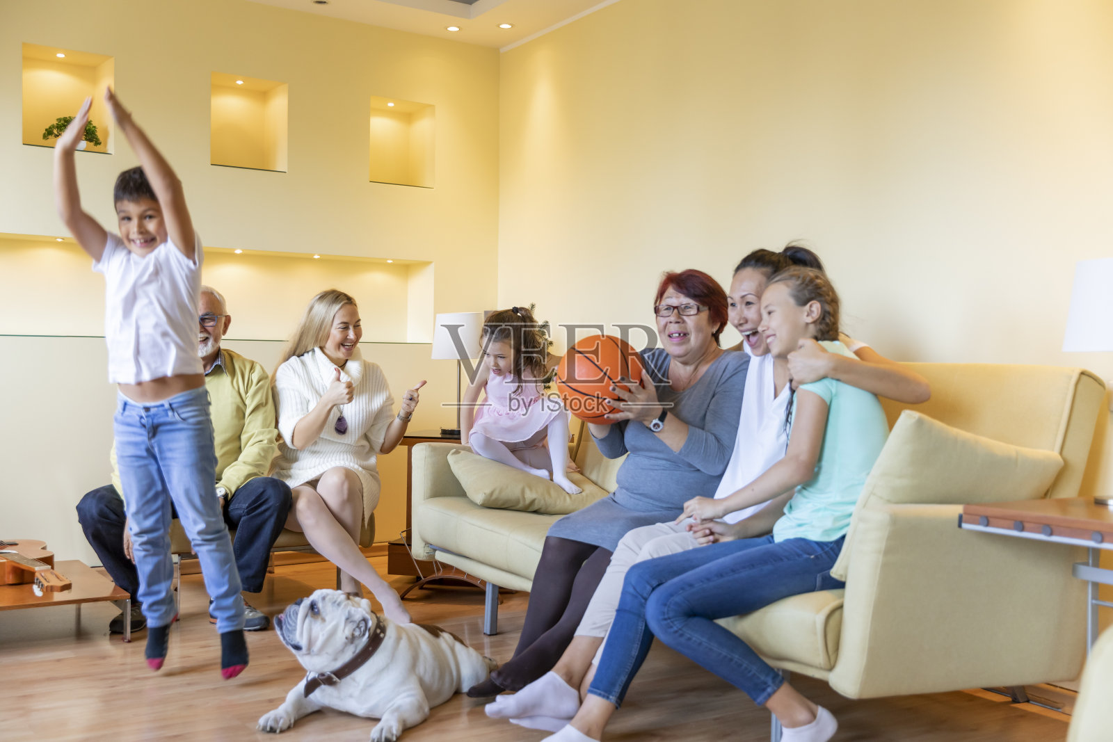 兴奋的多代同堂的家庭正在享受一场篮球比赛在家里。照片摄影图片