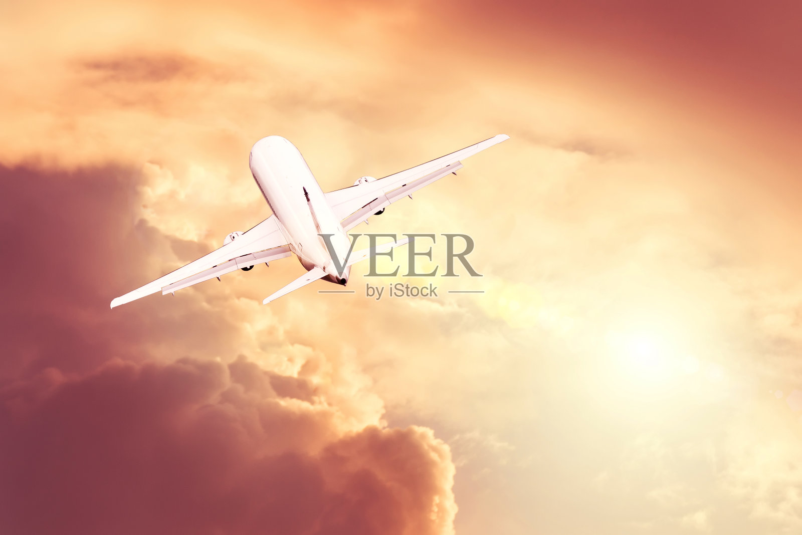 日落时分,一架商业客机在起飞上空降落。照片摄影图片