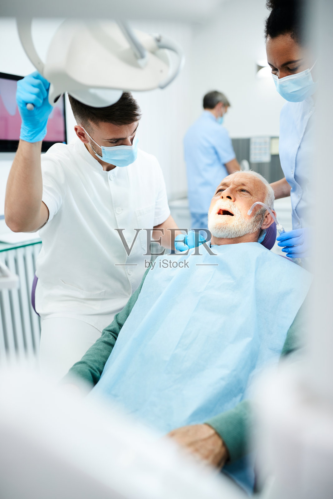 在牙科诊所让牙医检查牙齿的成熟男子。照片摄影图片