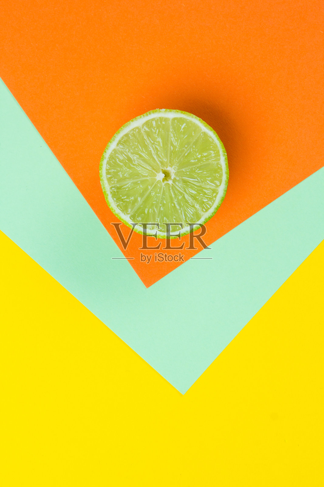 明亮的黄色,橙色和薄荷绿色背景上的石灰。照片摄影图片