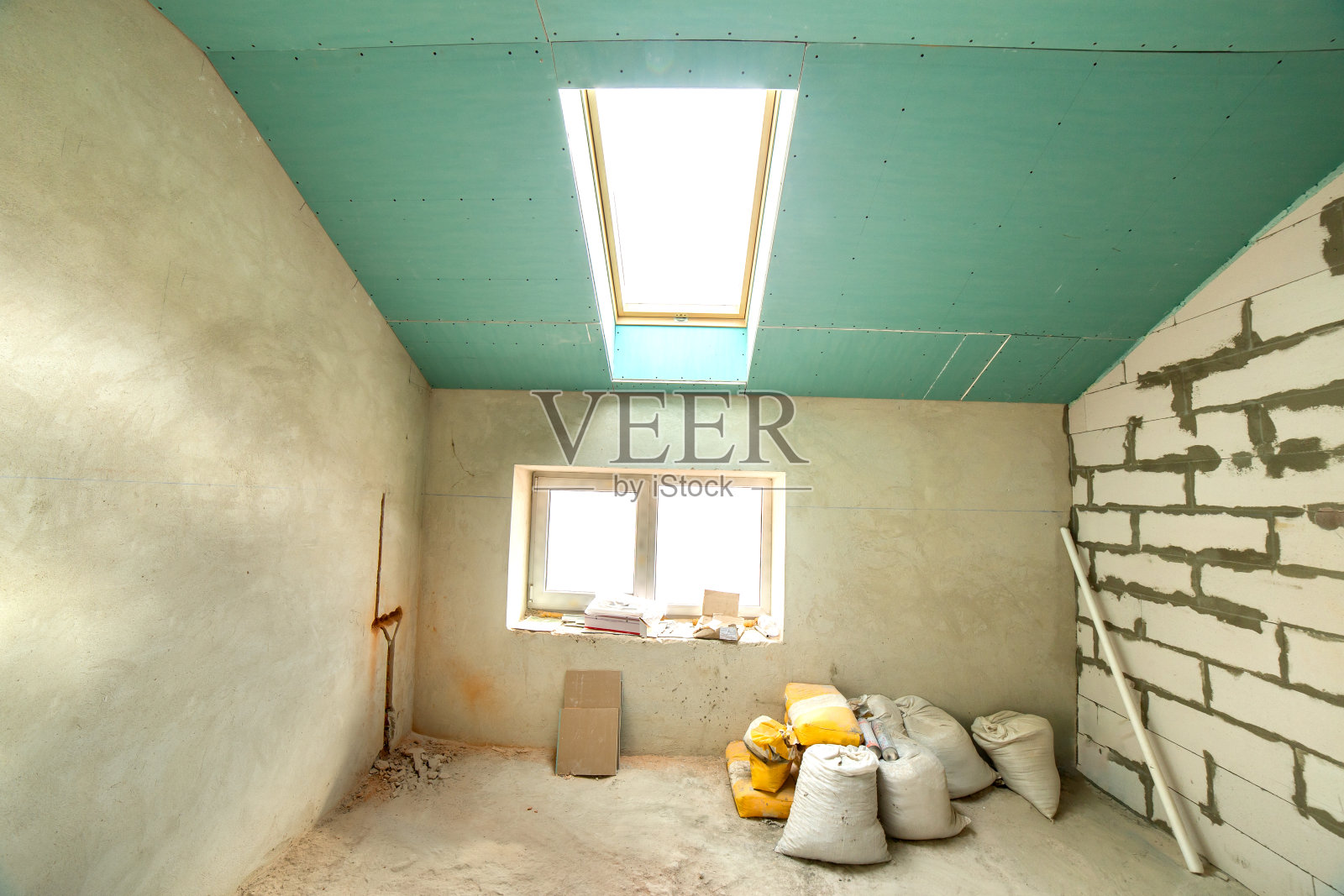 一间公寓房间的内部,裸露的墙壁和天花板正在施工中。照片摄影图片