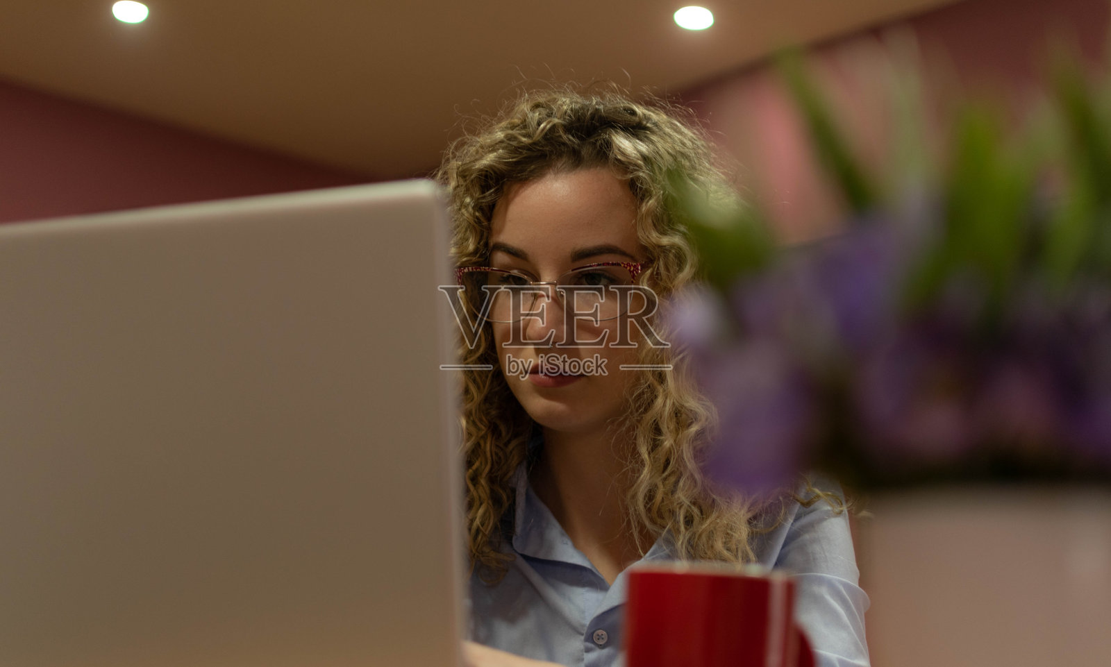 年轻美丽的女性卷发使用她的笔记本电脑在家里,放松,看电影,网上购物,年轻的学生学习,生活方式的概念,在她的家和她的阳台。照片摄影图片