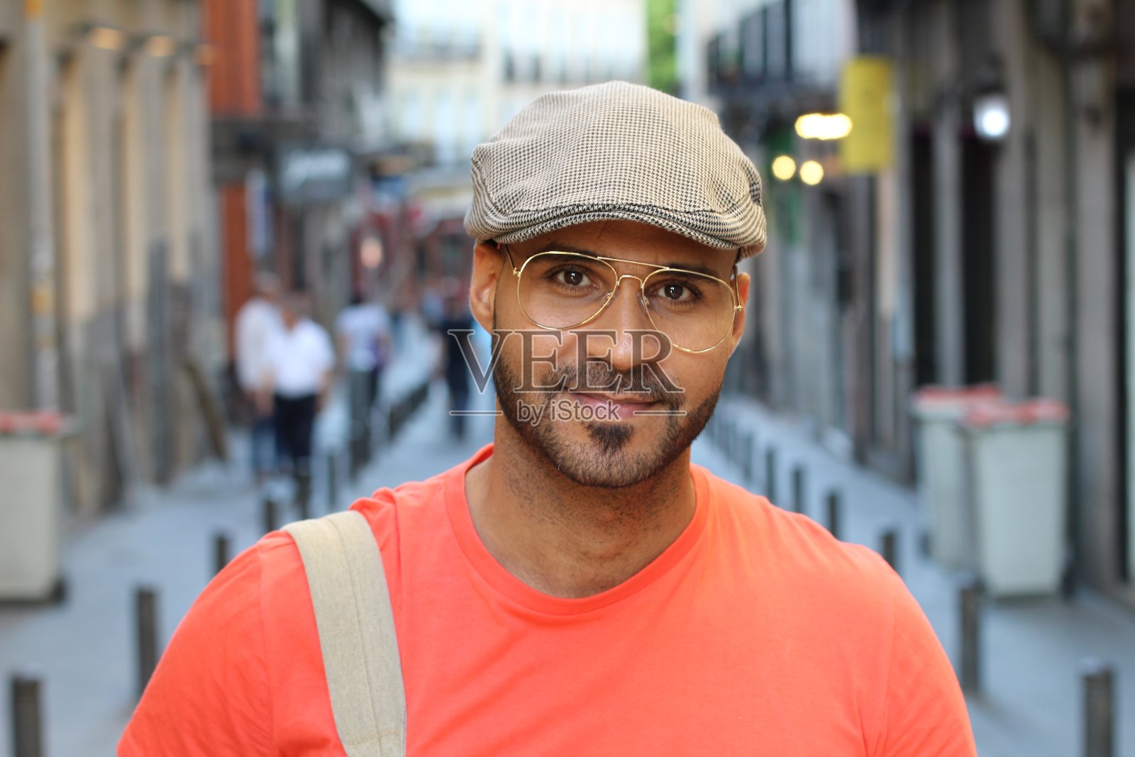 戴着眼镜和贝雷帽的年轻人在户外照片摄影图片