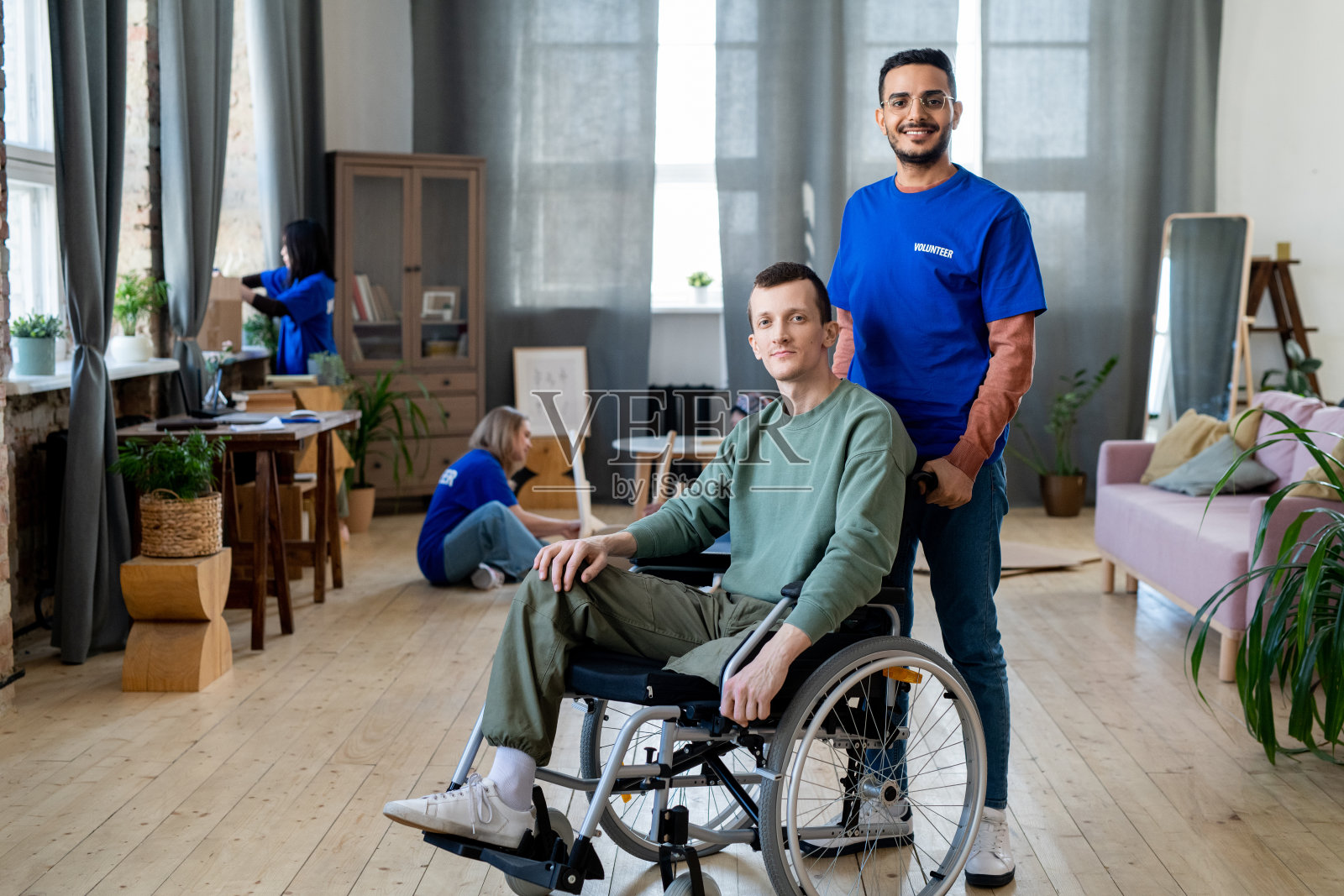 快乐年轻男性志愿者照顾残疾人照片摄影图片