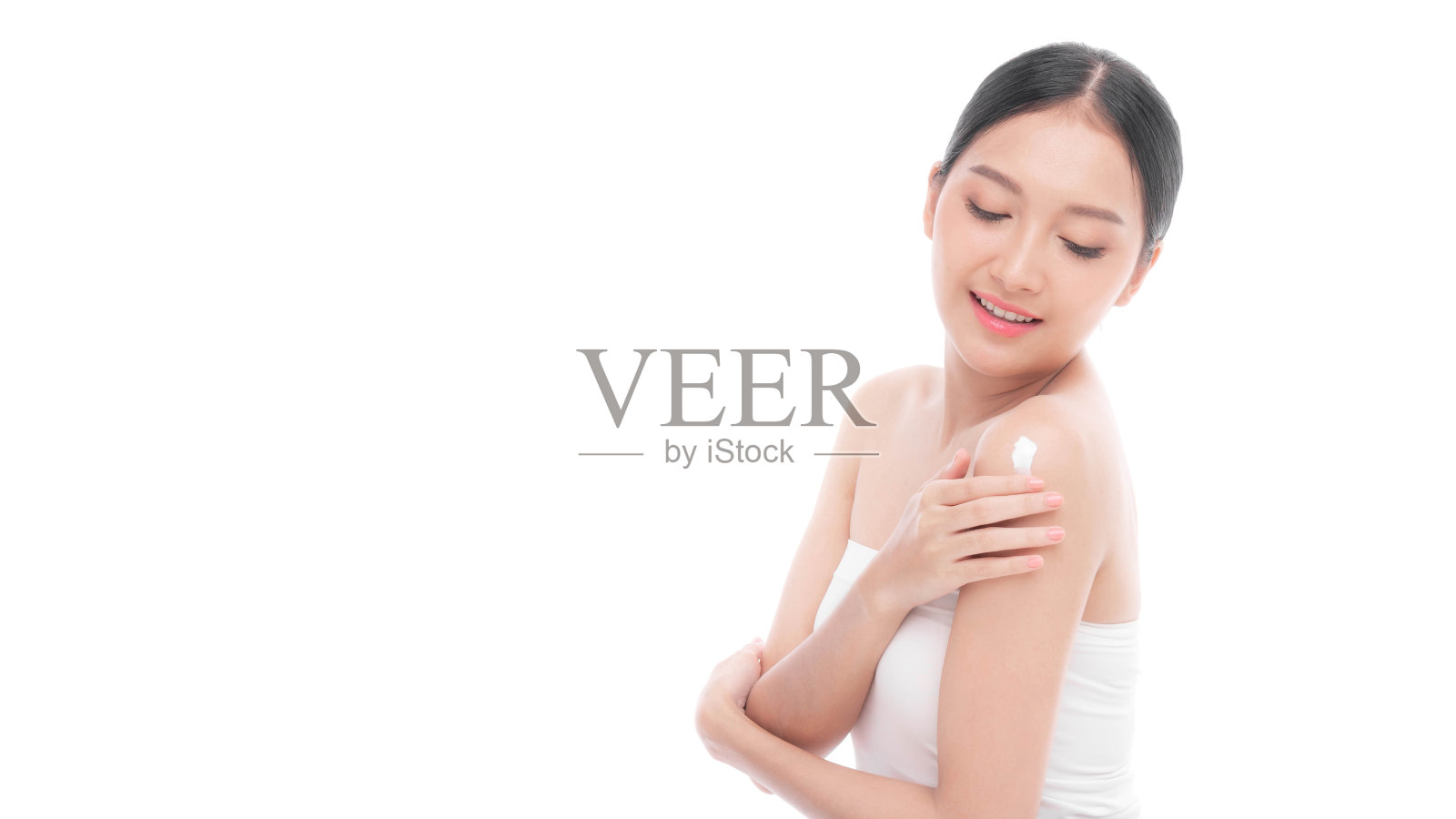 美丽的年轻亚洲女性,沐浴后使用身体乳液自然霜在肩膀上,皮肤干净,新鲜的皮肤,在白色的背景-面部治疗,美容,美容和水疗概念照片摄影图片