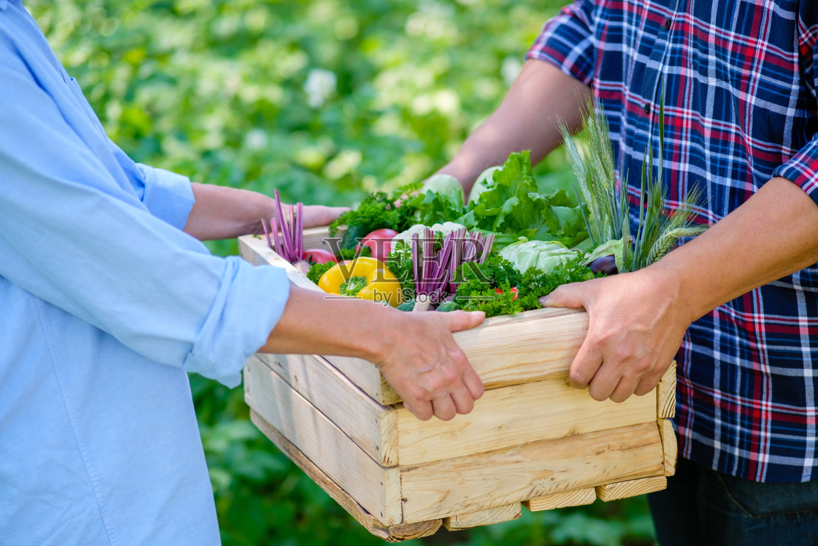 农夫在卖装着新鲜蔬菜的木箱。农场makert概念。照片摄影图片