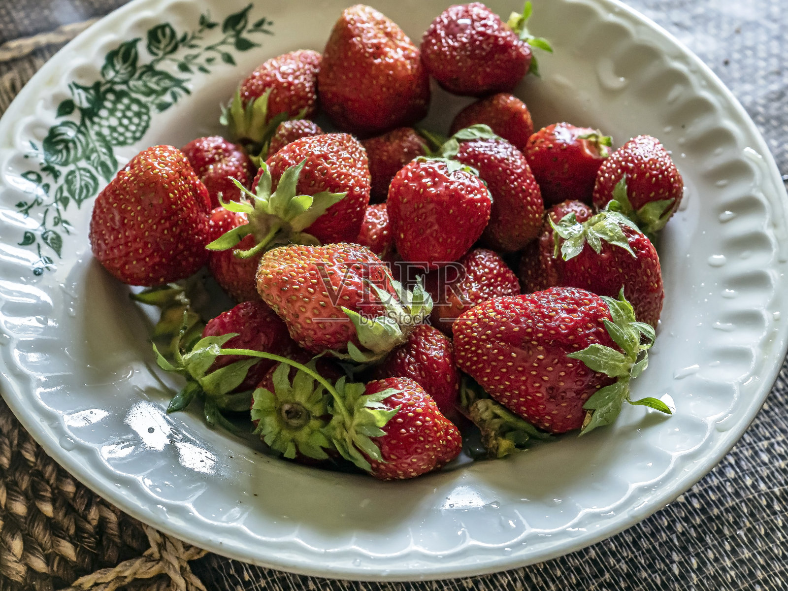 又红又熟的草莓放在盘子里照片摄影图片