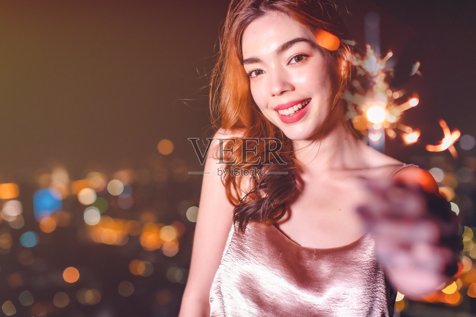 年轻的亚洲妇女跳舞和庆祝新年派对。年轻的时尚有野心的女人在霓虹灯下的镜头下看起来很紧张。夜生活,青春和城市氛围。照片摄影图片