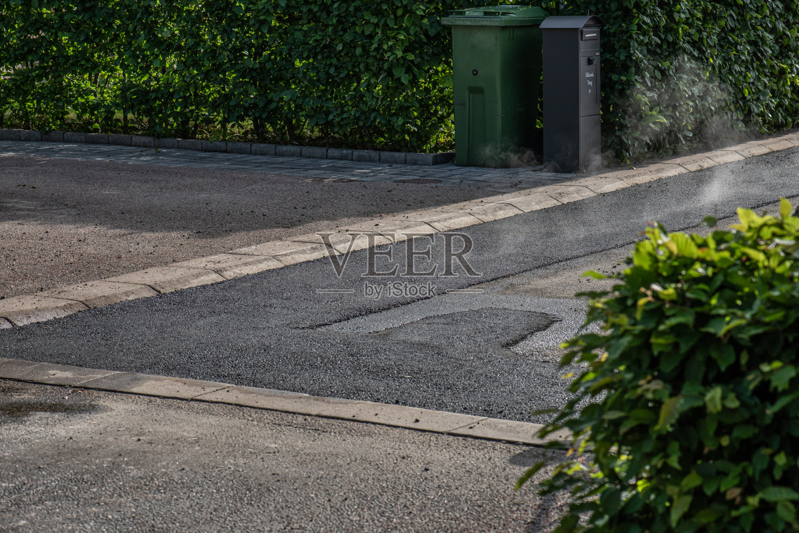 仍然温暖的沥青铺在一条小街道上。照片摄影图片