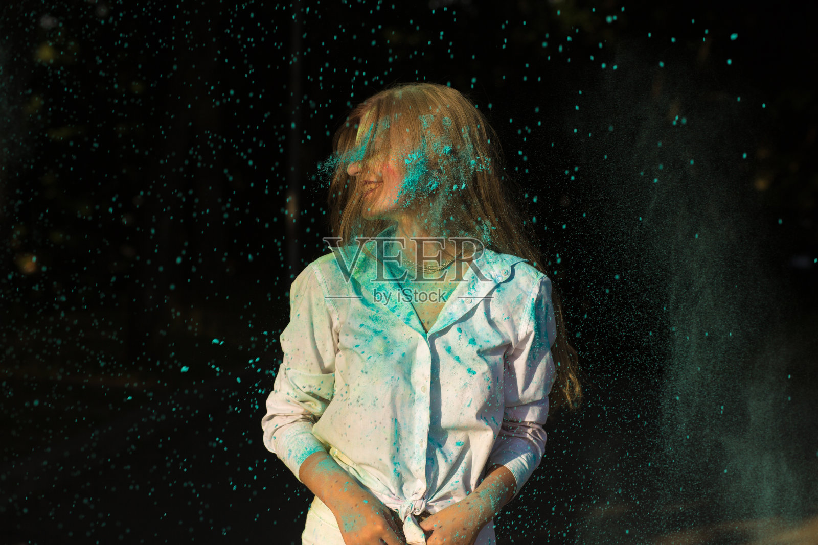 快乐的金发女人穿着白衬衫在公园庆祝胡里节照片摄影图片