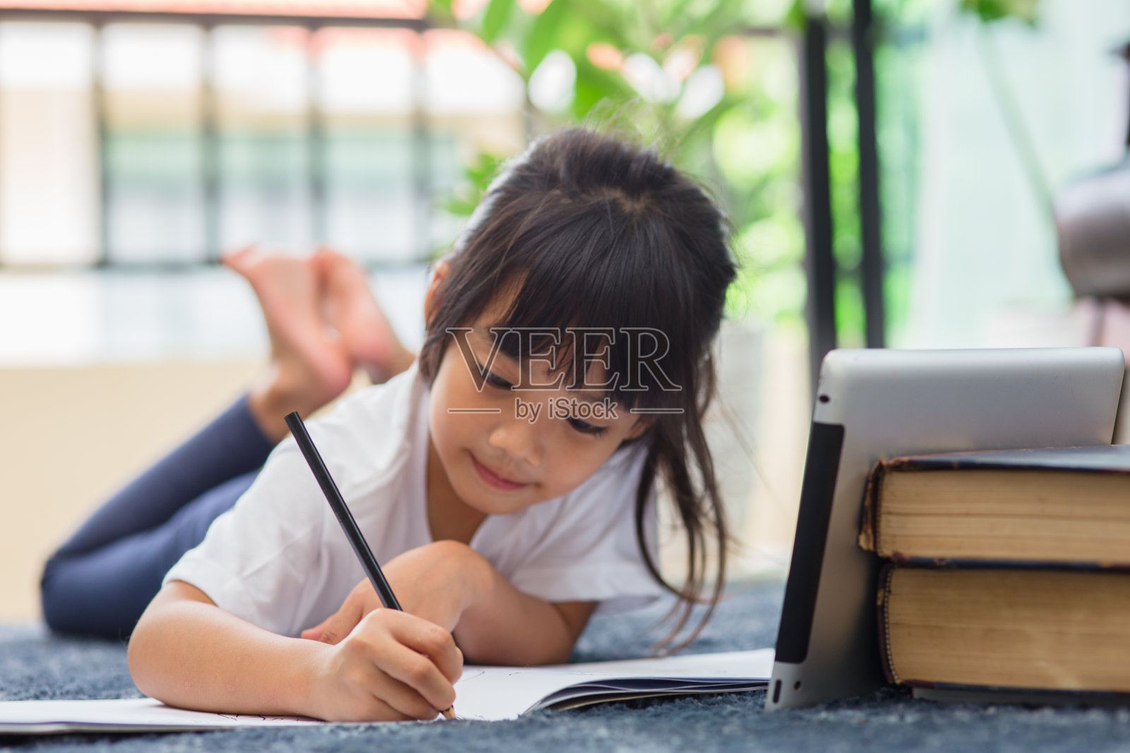 学前儿童使用平板电脑做作业的肖像,软焦点儿童做作业使用数码平板电脑在互联网上搜索信息,E-learning或家庭教育的概念照片摄影图片