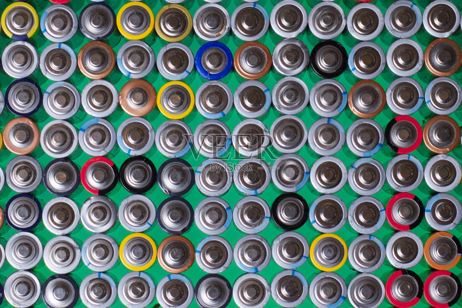 几节碱性电池在绿色背景上相互叠加照片摄影图片