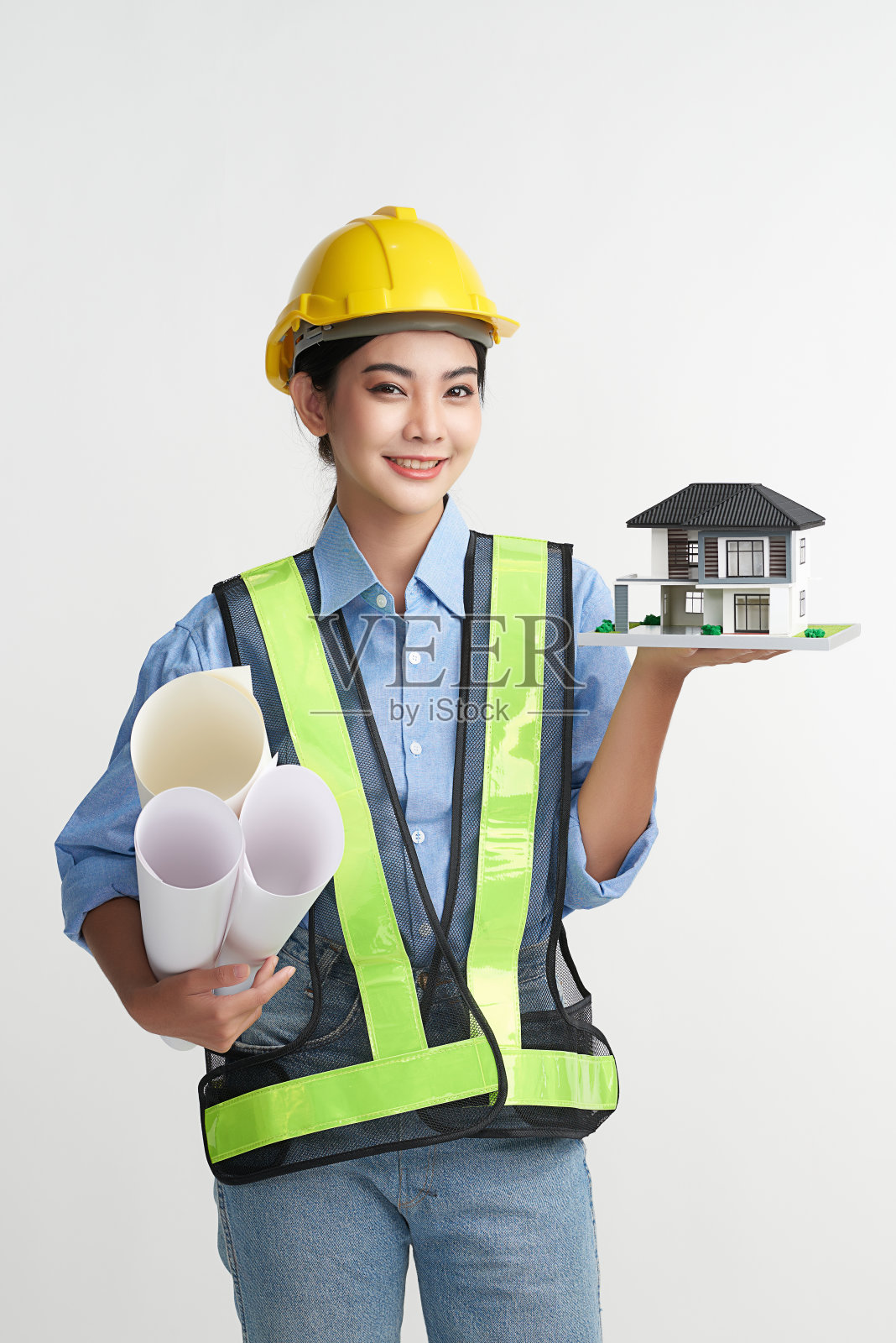 美丽的年轻亚洲女性工程师持有展示房子模型在白色背景,建筑概念,工程师,工业。照片摄影图片
