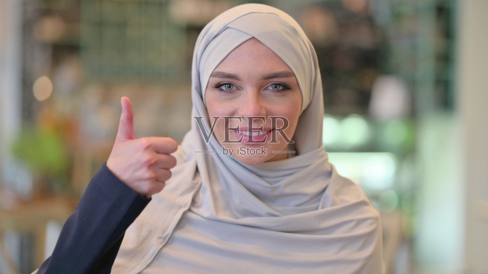 积极的年轻阿拉伯妇女竖起大拇指的肖像照片摄影图片