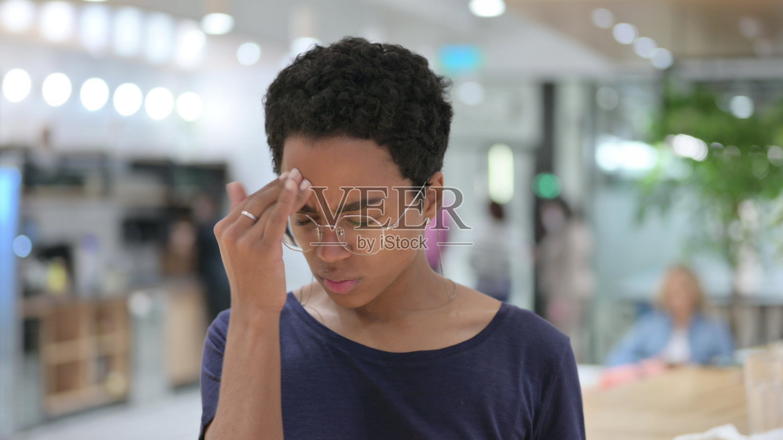 患有头痛的有压力的年轻非洲女性肖像照片摄影图片